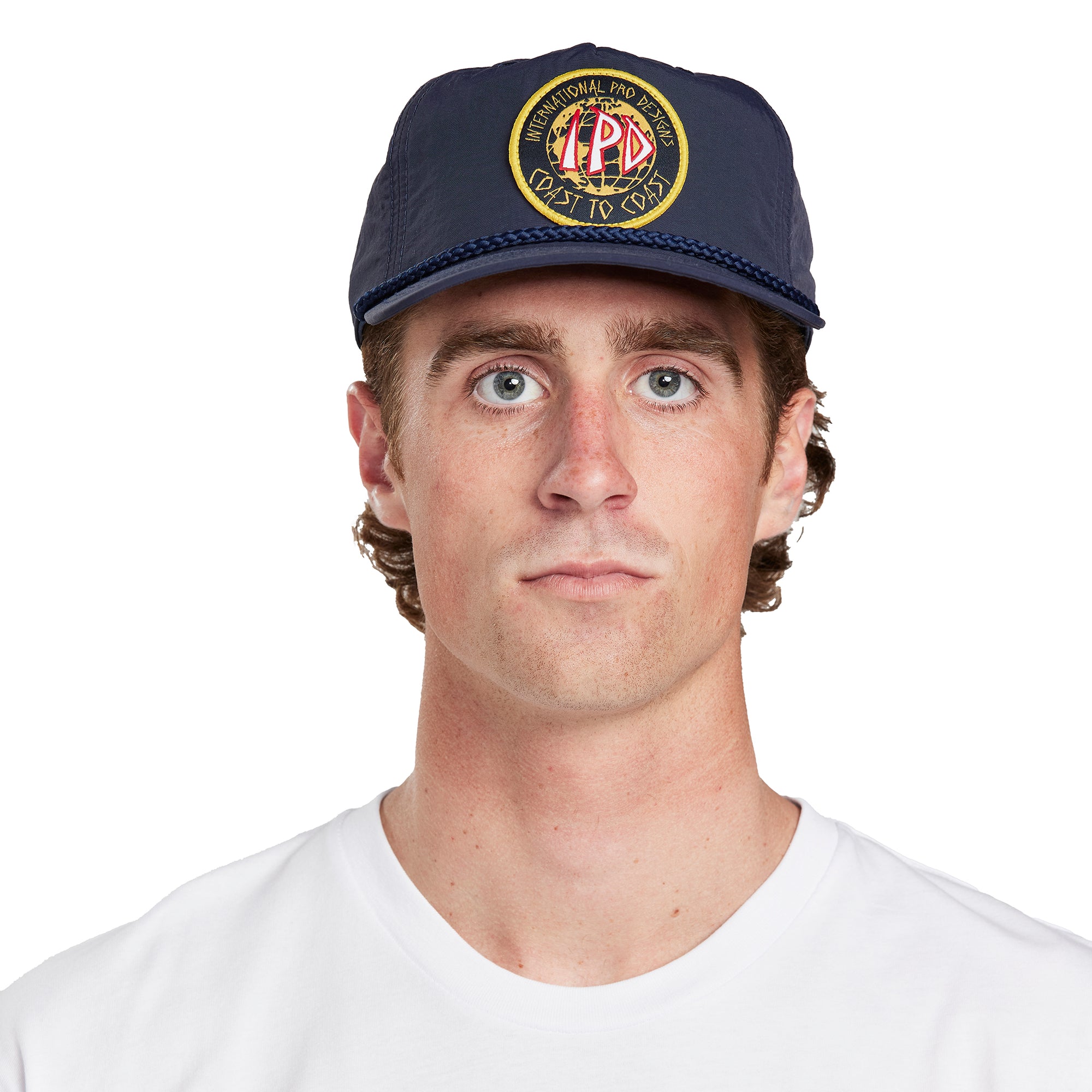  A young man wearing an Atlas navy hat, angled front view, showcasing the logo on the front of the hat.