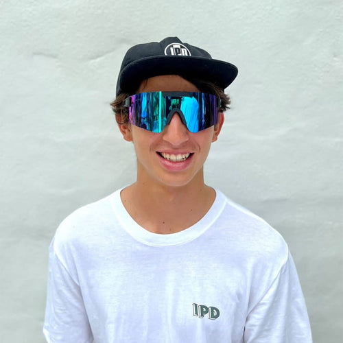 diego wearing some wide frame sunglasses with an ipd hat and tee, looking stoked with a big smile on his face