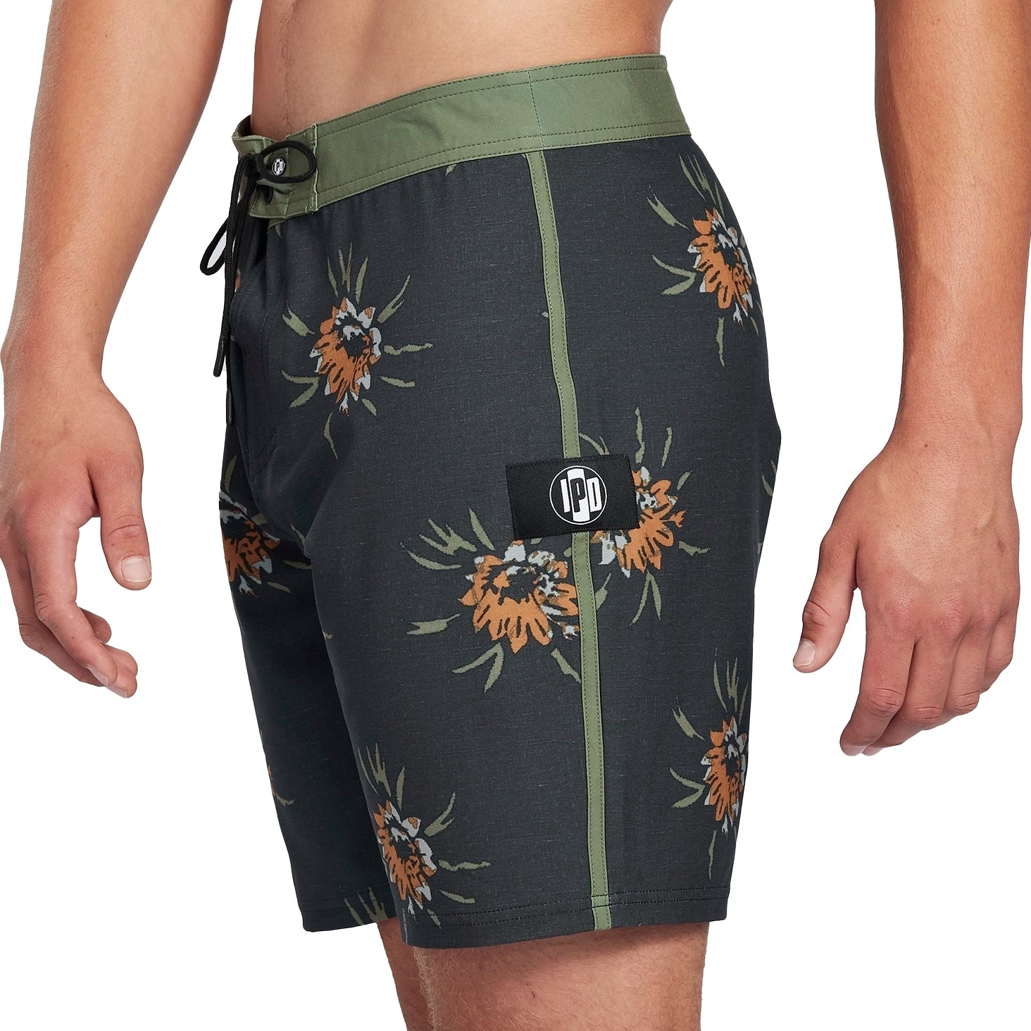 Black boardshorts with green trim and floral pattern front.