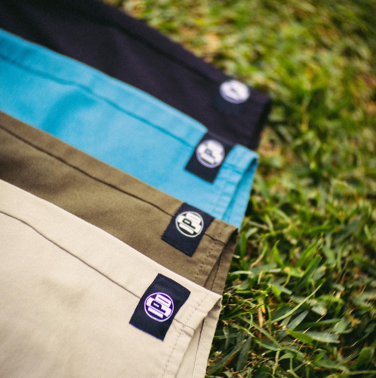 dune gray - bottom corner featuring the circular IPD logo of all four color on the grass