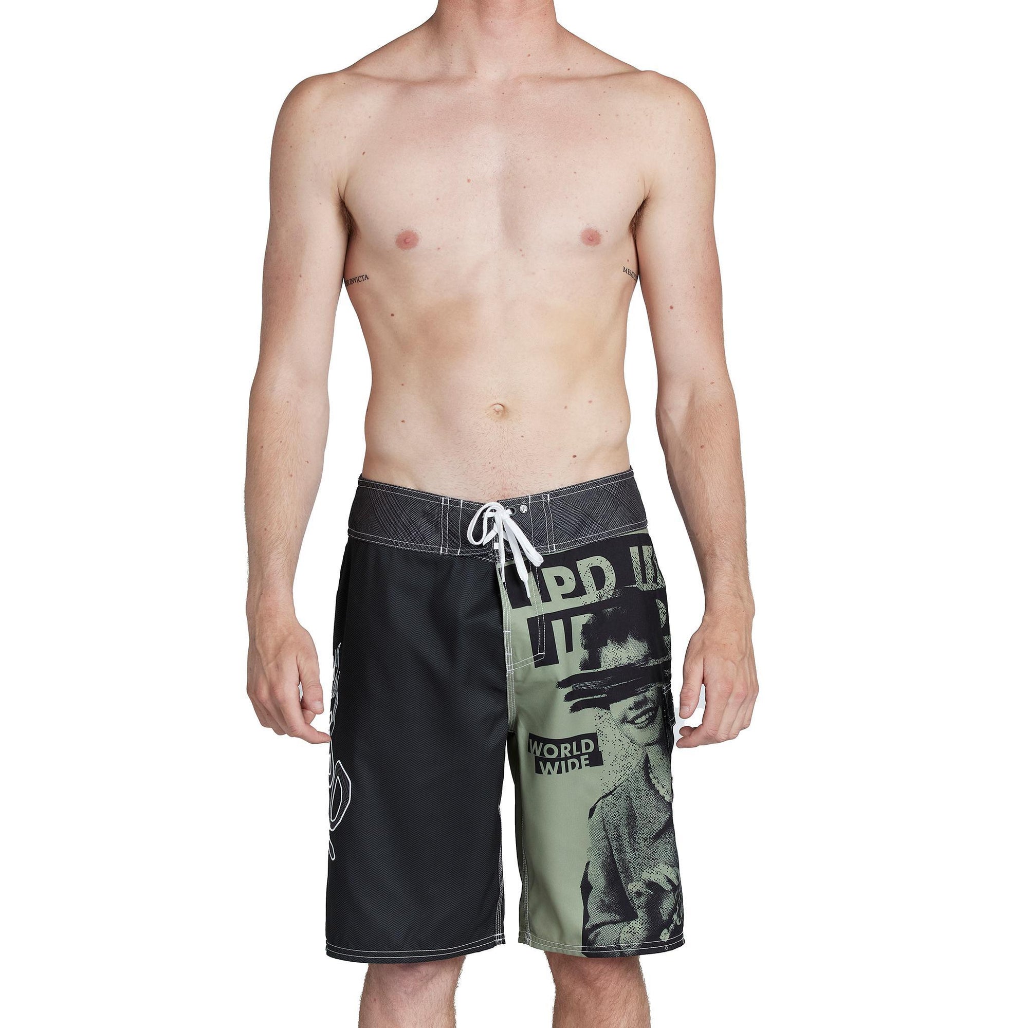 model wearing mens faceplant y2k fit 22&quot; boardshort in black showing large graphic on left leg with woman surrounded by IPD logos and lerge IPD on right leg and tie closure on waist 
