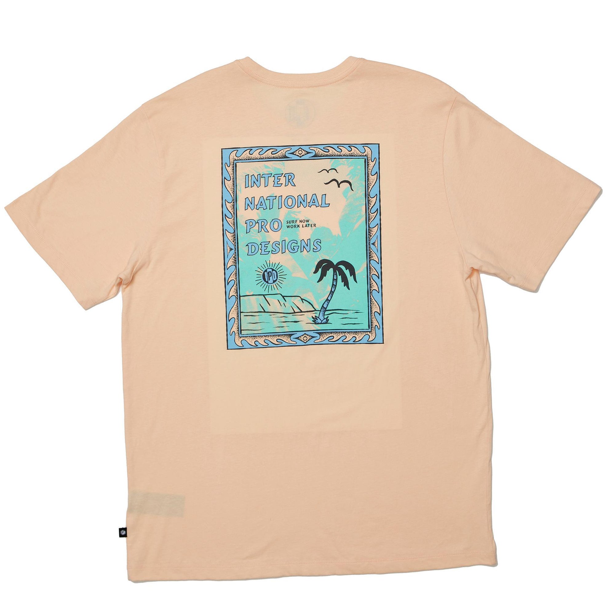 modeling showing the rear view of the mens framed super soft s/s tee in sherbert. showing the large rear graphic of stamp with international pro designs by a palm tree
