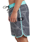 Side view of black and silver abstract striped boardshorts mimicking sound frequency with turquoise trim and an I P D logo on the side.