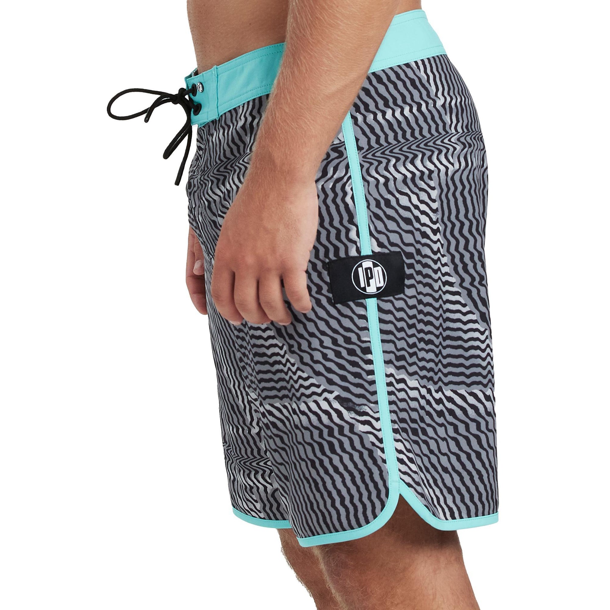 Front side view of navy blue and olive green abstract striped boardshorts with blends of red and an I P D logo on the side.