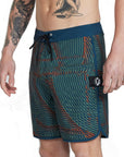 Front side view of navy blue and olive green abstract striped boardshorts with blends of red and an I P D logo on the side.