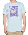 Front view of a light blue short sleeve tee with a purple-colored, retro, collage style print of an I P D logo on the broken screen of an old T V. The word Against is above the T V, the words The Grain are below the T V, and the words No Risk No Reward are at the bottom of the print.