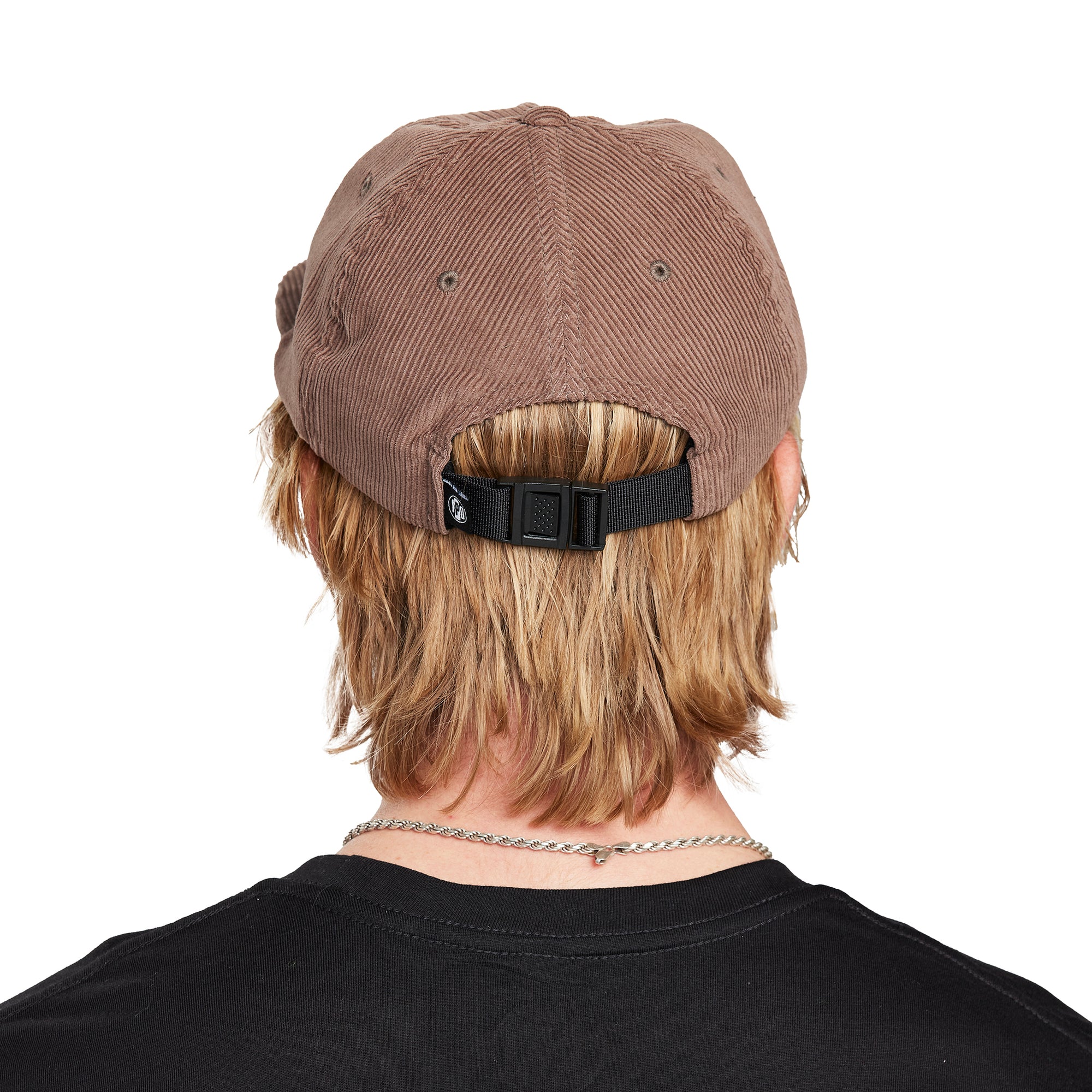 A young man wearing a Paradise brown hat, back view, displaying the adjustable strap and the back design of the hat.