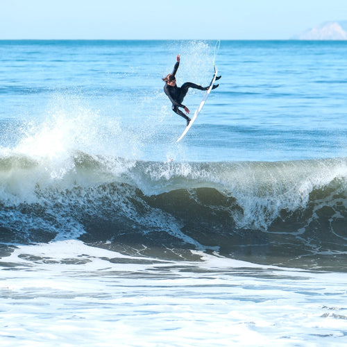 ryder catching a huge air off a breaking wave and tweaking his board