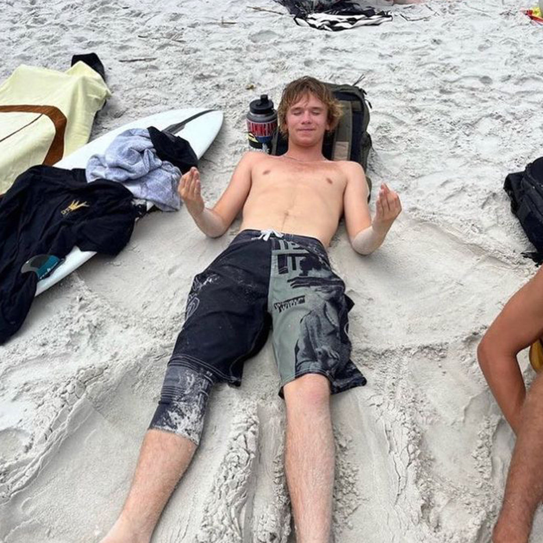 bear chilling on the beach lying down in the sand acting like he's meditating