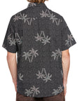 Back view of a black short sleeve shirt featuring an all-over palm tree print, offering a stylish, casual look with island vibes.