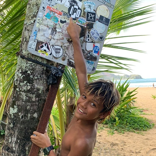 idren posting an IPD sticker on a post by the beach.