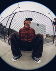 Man wearing the IPD Evergreen flannel shirt in burnt orange in an outdoor setting.