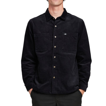 Front view of a man wearing the IPD Pierside corduroy shirt in black with dual chest pockets.