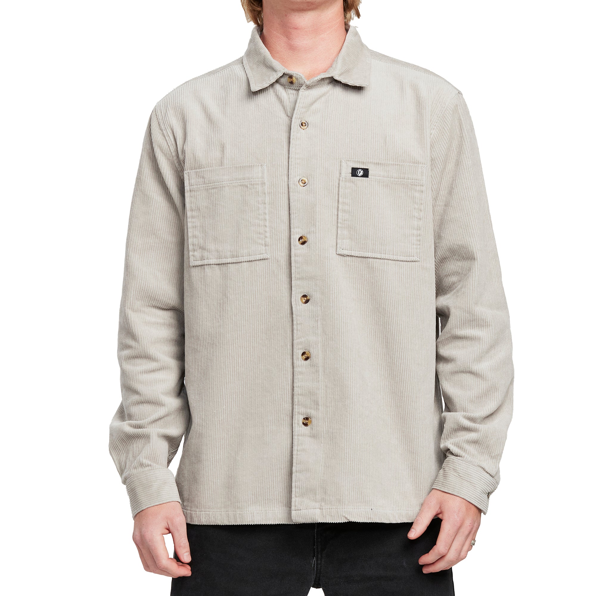 Front view of a man wearing the IPD Pierside corduroy shirt in haze with dual chest pockets.