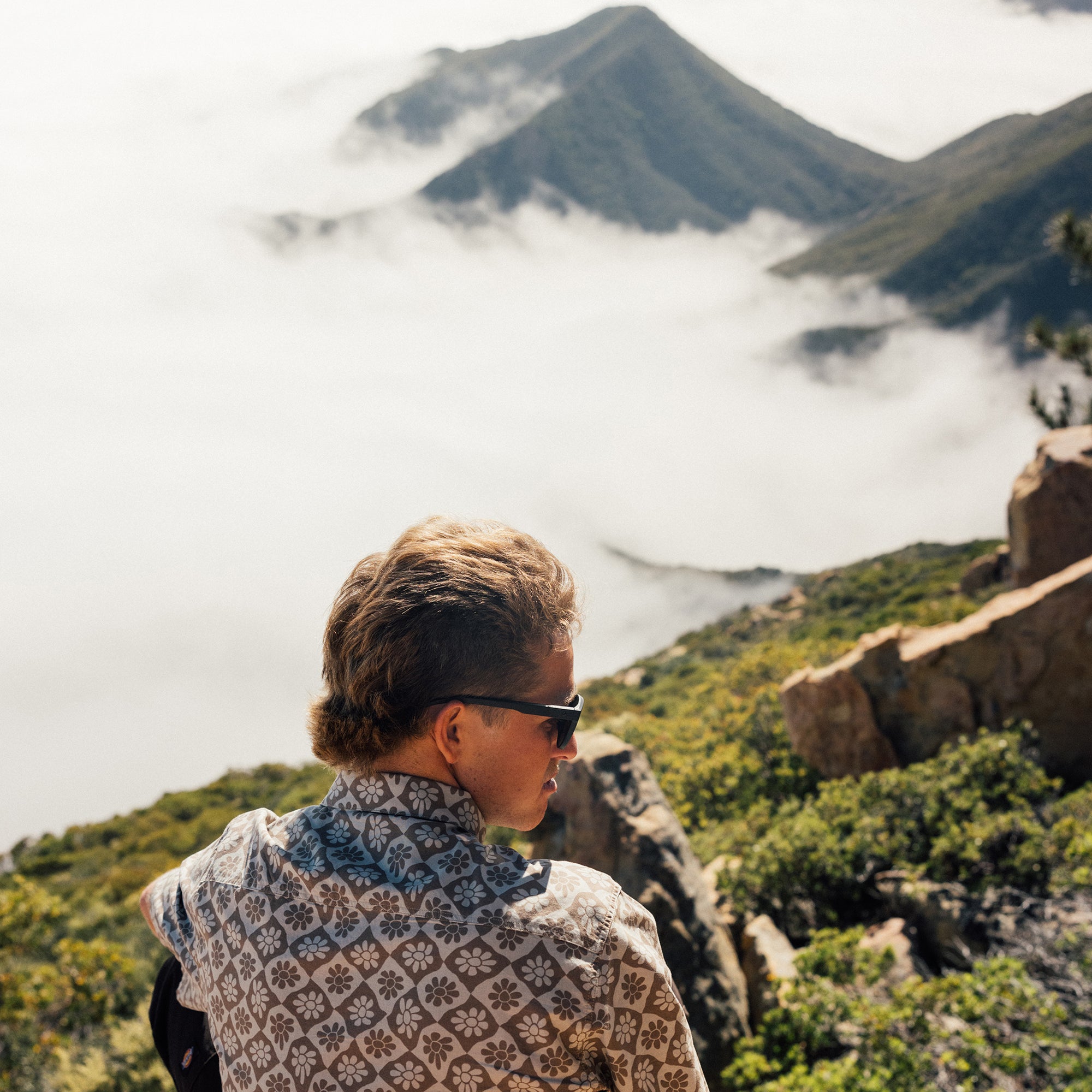 Man wearing the IPD Rudy short sleeve woven shirt in an outdoor setting with mountains in the background.