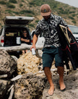 Man wearing the IPD Spinner short sleeve woven shirt in an outdoor setting with a rocky landscape in the background.