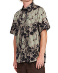 Side view of an olive Hawaiian print short sleeve button-up shirt featuring a bold black floral pattern, perfect for a laid-back tropical vibe.
