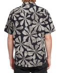 Back view of a man wearing the IPD Spinner short sleeve woven shirt with a black and gray floral pattern.