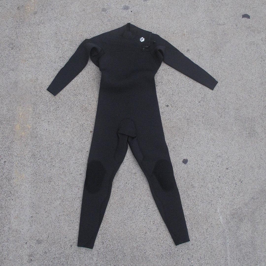 front view of men&#39;s 3M front chest full body wetsuit while laying on ground. I P D circle logo on left shoulder with zipper running across chest from left to right side. 