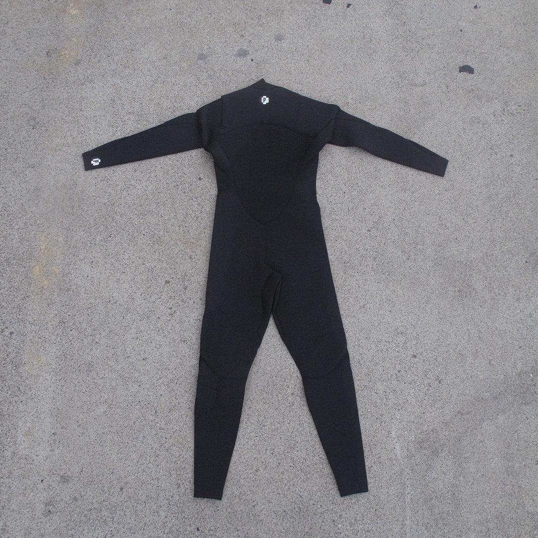 back side of full body wet suit while laying on ground.  I P D circle logo at base of neck and on right wrist 