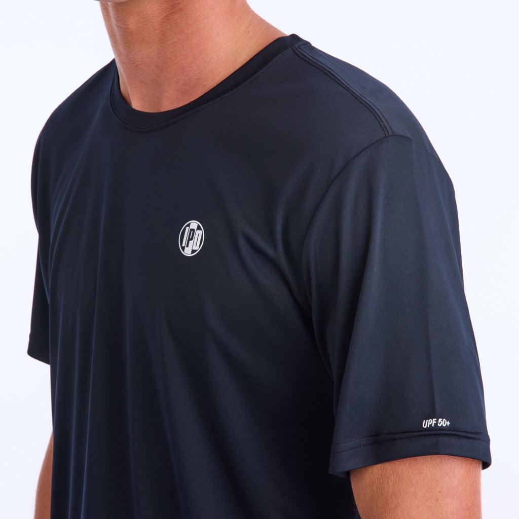 Front side view of a black polyester water resistant short sleeve Low Key Surf Shirt with a small I P D logo over the heart.