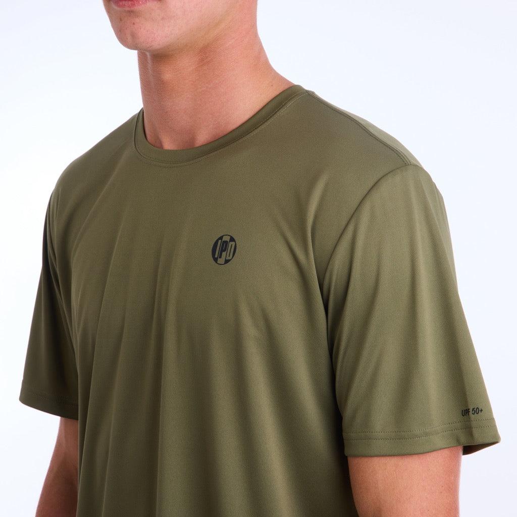 Front side view of an olive green polyester water resistant short sleeve Low Key Surf Shirt with a small I P D logo over the heart.