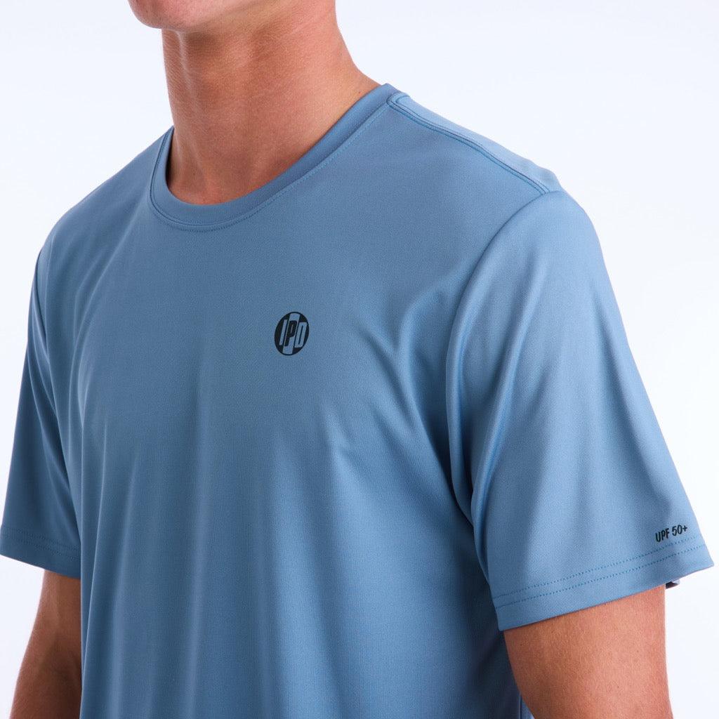 Front side view of a light blue polyester water resistant short sleeve Low Key Surf Shirt with a small I P D logo over the heart.