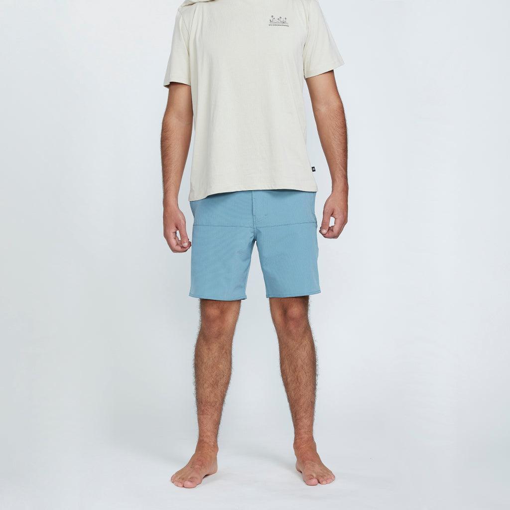 The front view of a man wearing blue shorts with two side pockets.