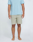 The front view of a man wearing tan shorts with two side pockets.