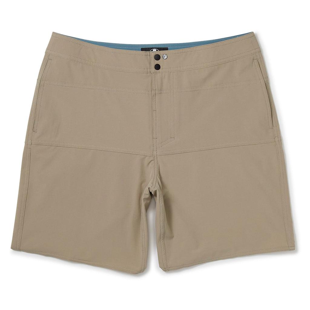 The front view of tan shorts with two side pockets, two metal snaps at the closure, and a small circular I P D logo to the left of the snaps. The waistband has two double rows of stitching. There is also double stitching along the edges of a horizontal rectangular section located below the waist, above the crotch and extending to the left and right side seams.