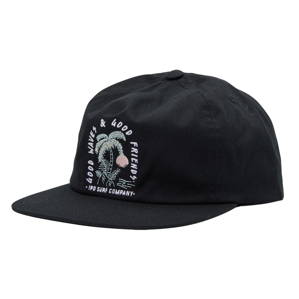 The Good Friends Good Waves Hat features an unstructured snapback styling in the color black. It features an embroidered image on the front of rocks, a palm tree, and the sun, in the colors sage and pink. It reads good friends and good waves arced around the image and ipd surf company underneath both in white