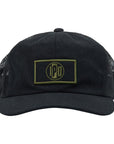 The 1697 Trucker Snapback features a lower profile trucker styling in the color black with a black mesh back. It features a brown and black rectangular front patch with the I P D logo in the center.