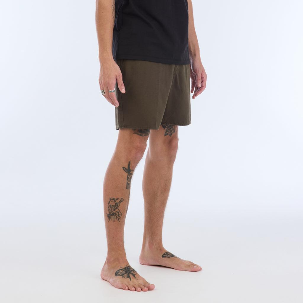 on model with black top:The Foundation Walkshort is a classic walkshort silhouette that comes in at a 17” length. It features a solid olive coloring, and features an elastic waistband and drawcord. The pocketing is two side pockets and two back patch pockets. It features the signature smaller IPD flag label on the lower left leg.