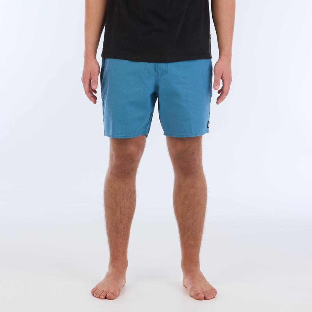 on model with black top:The Foundation Walkshort is a classic walkshort silhouette that comes in at a 17” length. It features a solid blue coloring, and features an elastic waistband and drawcord. The pocketing is two side pockets and two back patch pockets. It features the signature smaller IPD flag label on the lower left leg.
