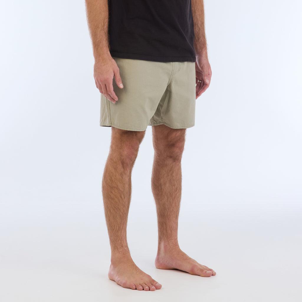 on model with black top, side view:The Foundation Walkshort is a classic walkshort silhouette that comes in at a 17” length. It features a solid gray coloring, and features an elastic waistband and drawcord. The pocketing is two side pockets and two back patch pockets. It features the signature smaller IPD flag label on the lower left leg.