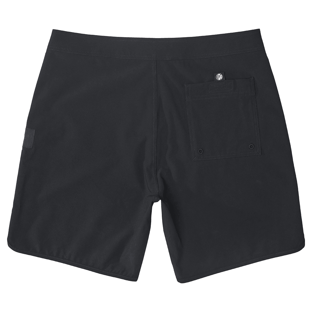 Rear view of simple, solid black boardshorts with a classic style and back pocket with a small I P D logo above it.
